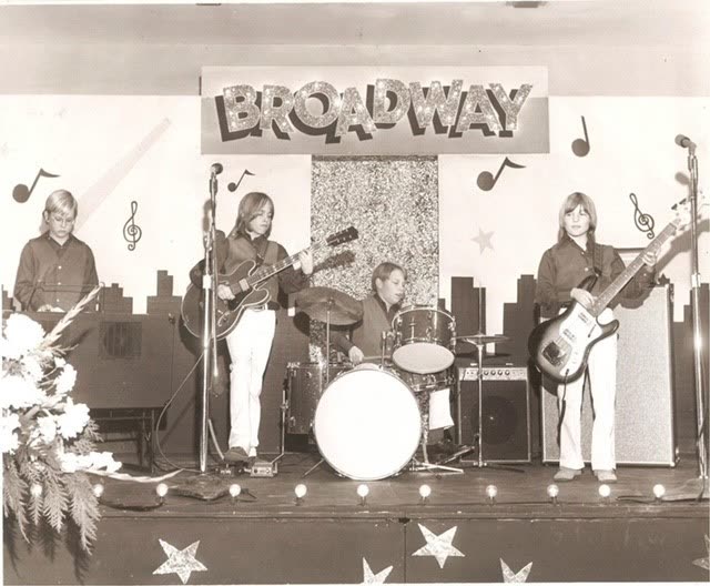 A young John Seppala's band performing on stage under a Broadway banner